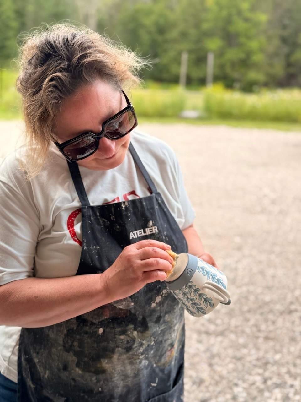 Ysabel fait la finition d’une tasse à l’atelier